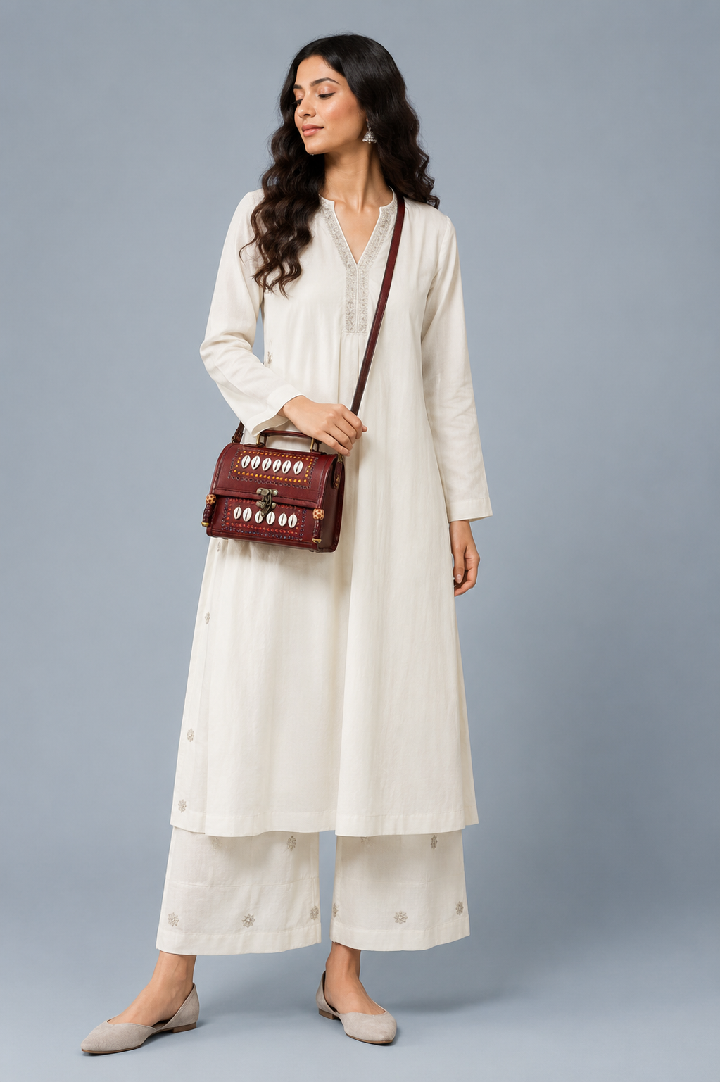 Brown leather cowrie shell trunk bag — lifestyle with white kurta
