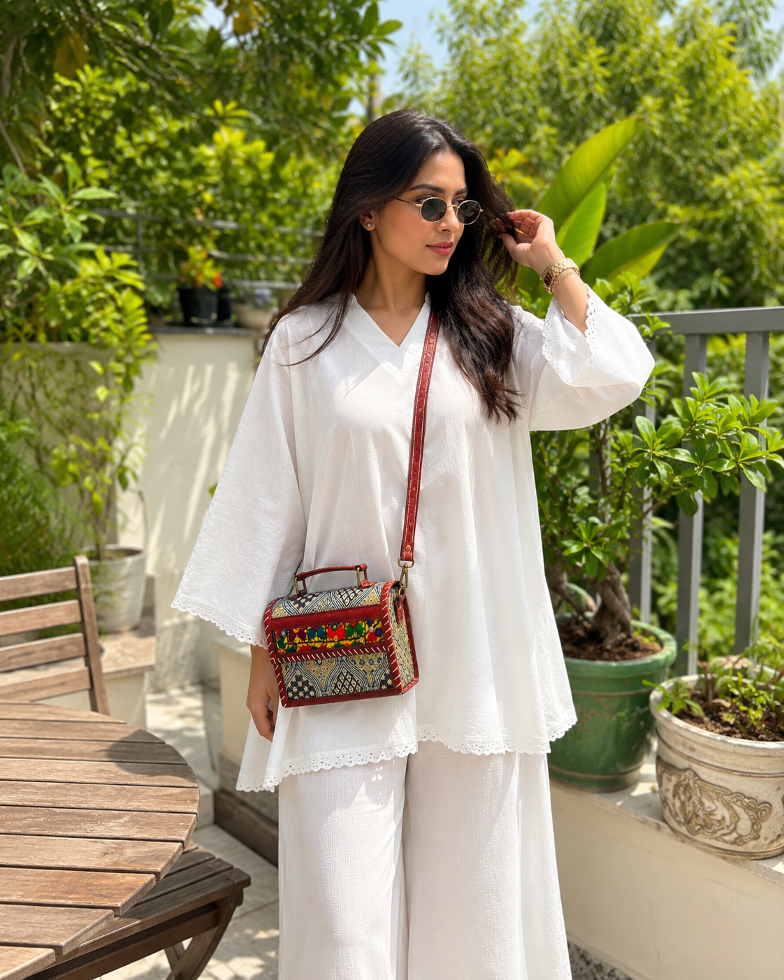 Multicolour Banjara crossbody trunk bag — lifestyle with white kurta
