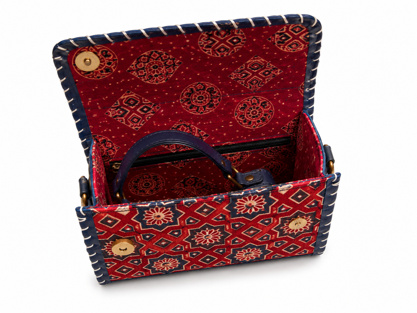 A small open handbag with a red and navy patterned exterior and lining, featuring a dark blue handle and gold-tone hardware, shown on a white background.